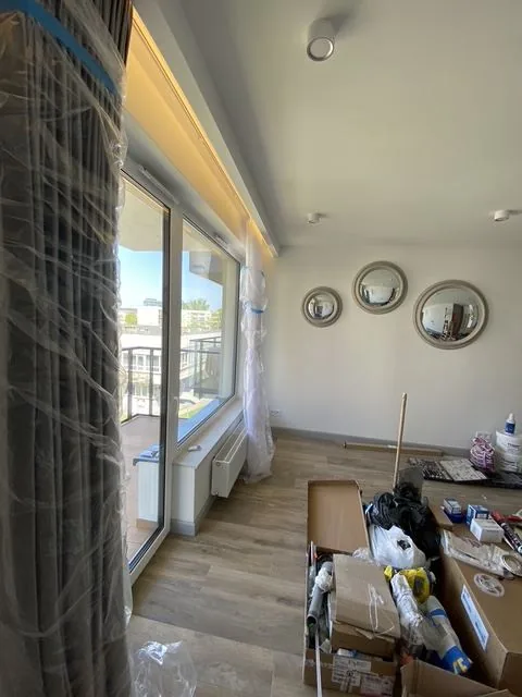 Pokój z wyjściem na balkon, zasłonami i dekoracyjnymi lustrami